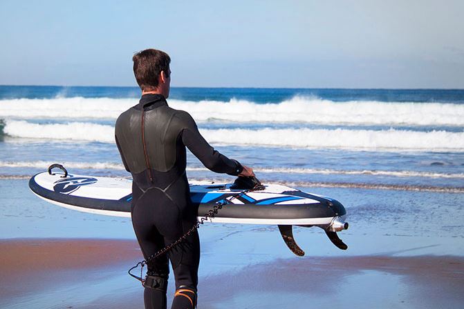 Onean-Carver-Elektro-Surfboard-E-Jetboard-Mann träft Board ins Wasser