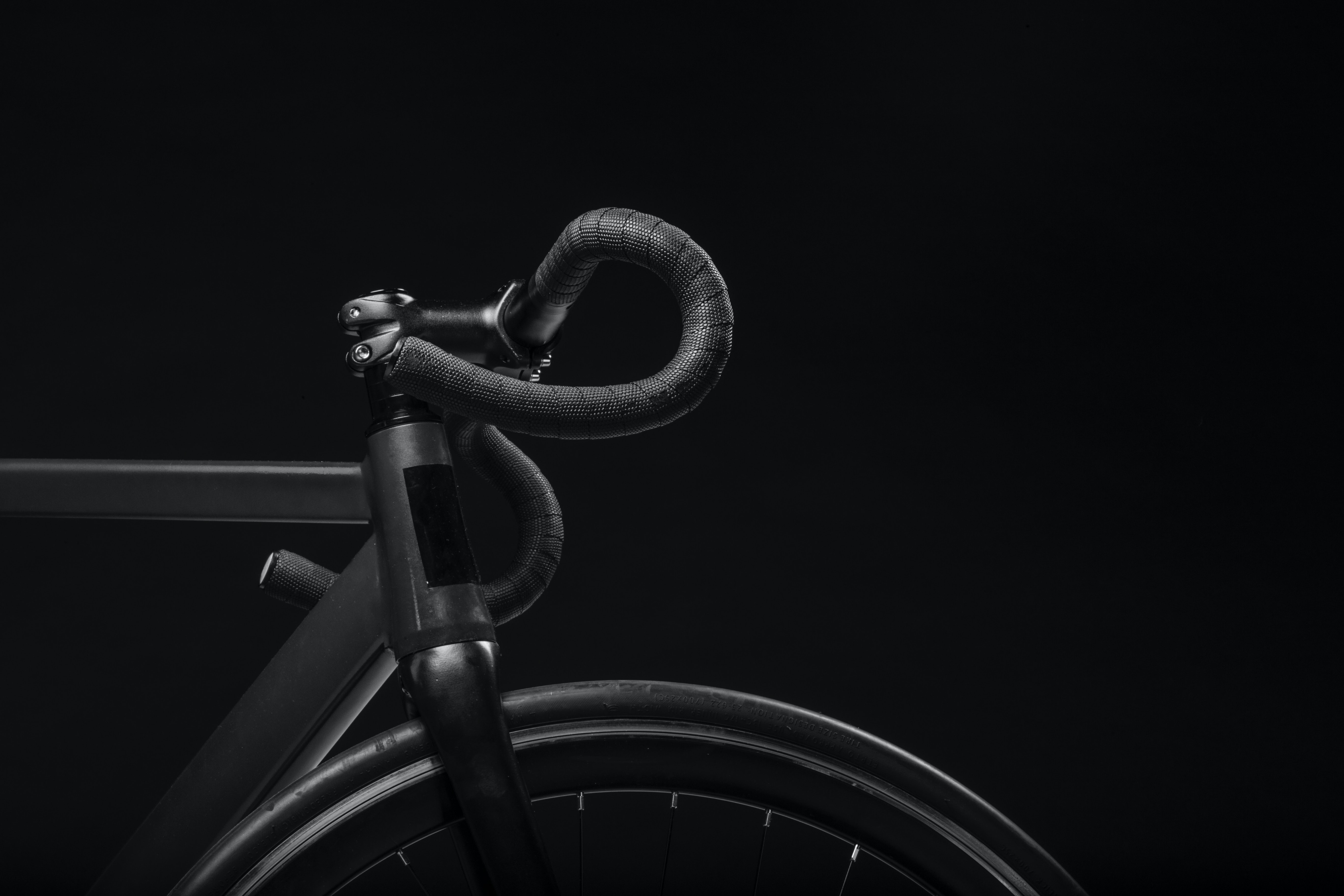 E-Bike Versicherung schwarzes Rad vor schwarzem Hintergrund