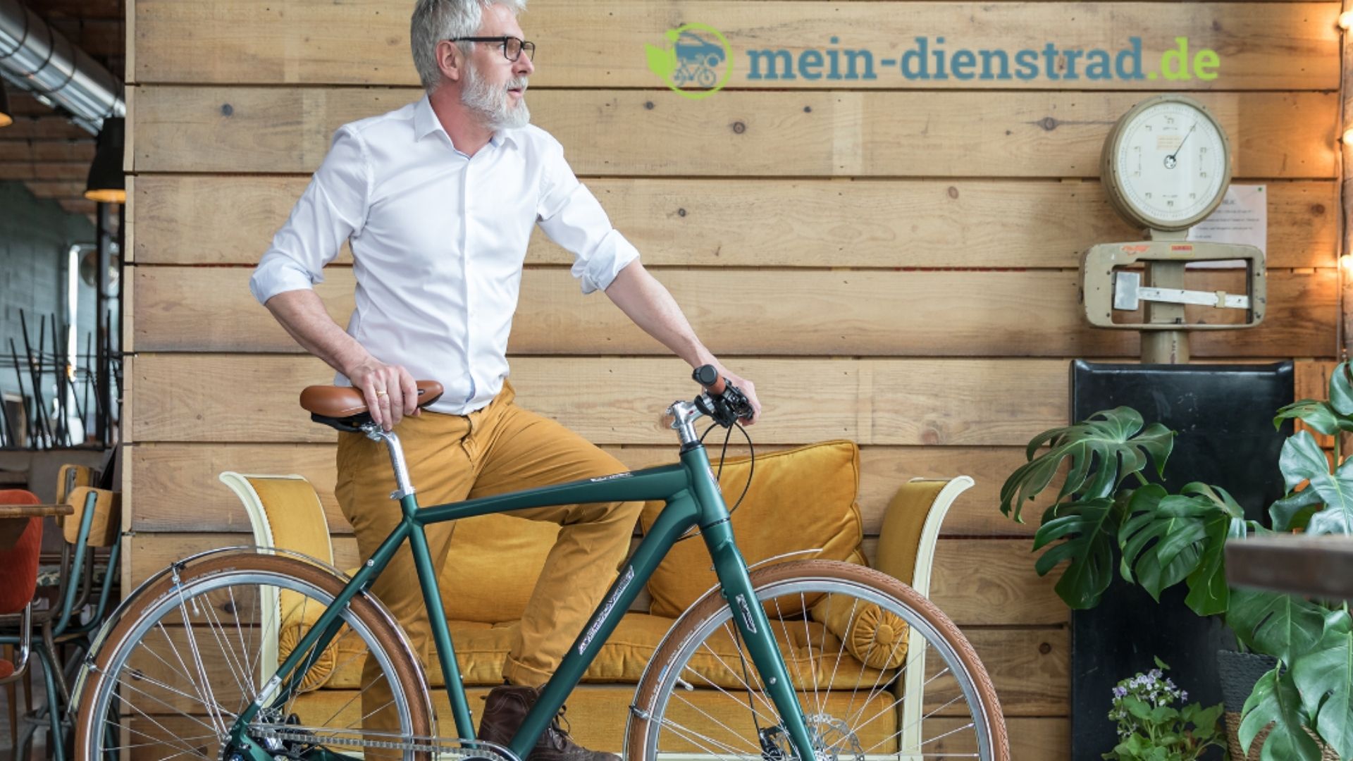 Dein Dienstrad Mann mit Fahrrad vor Holzwand